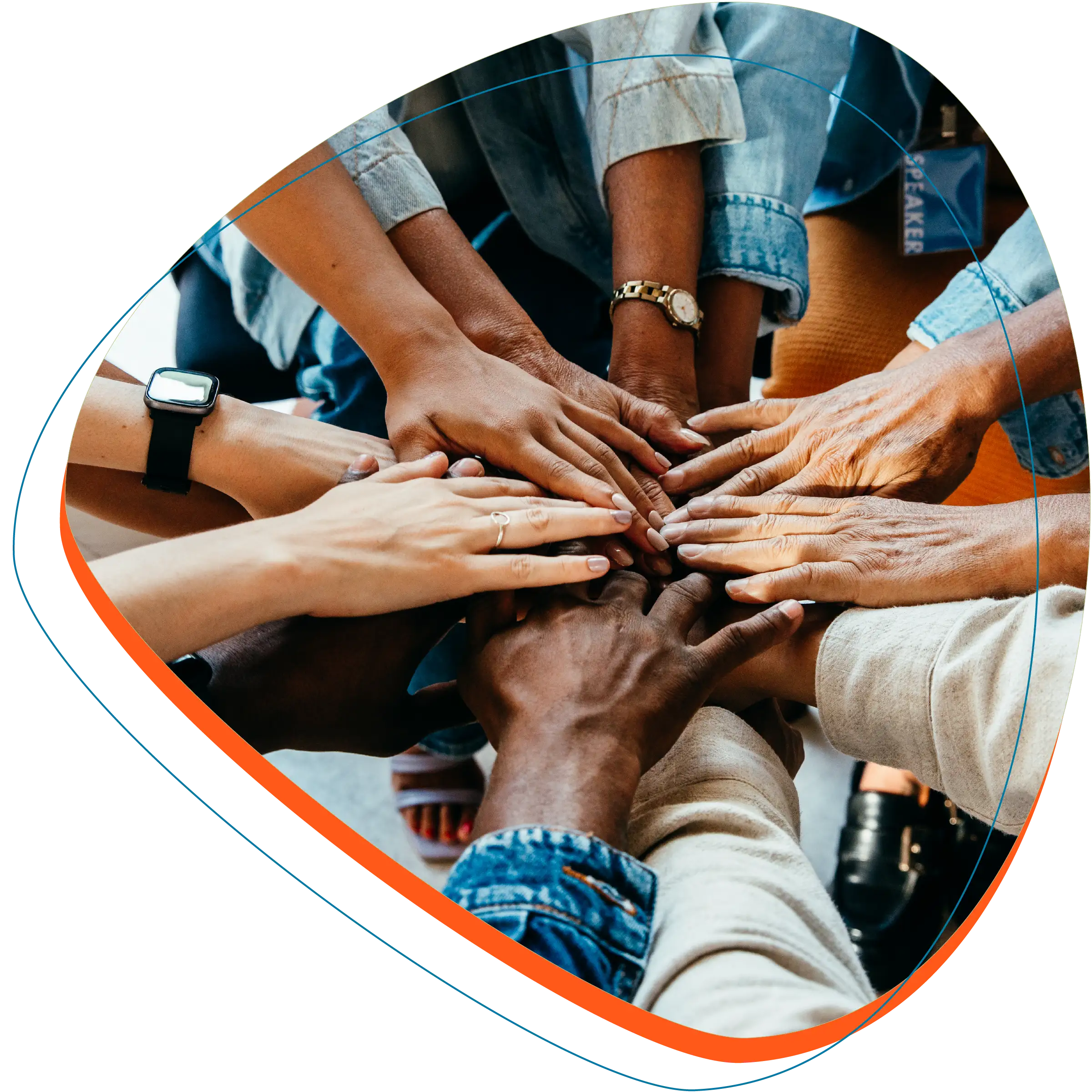 Circle of people all with their hand connecting in the middle.