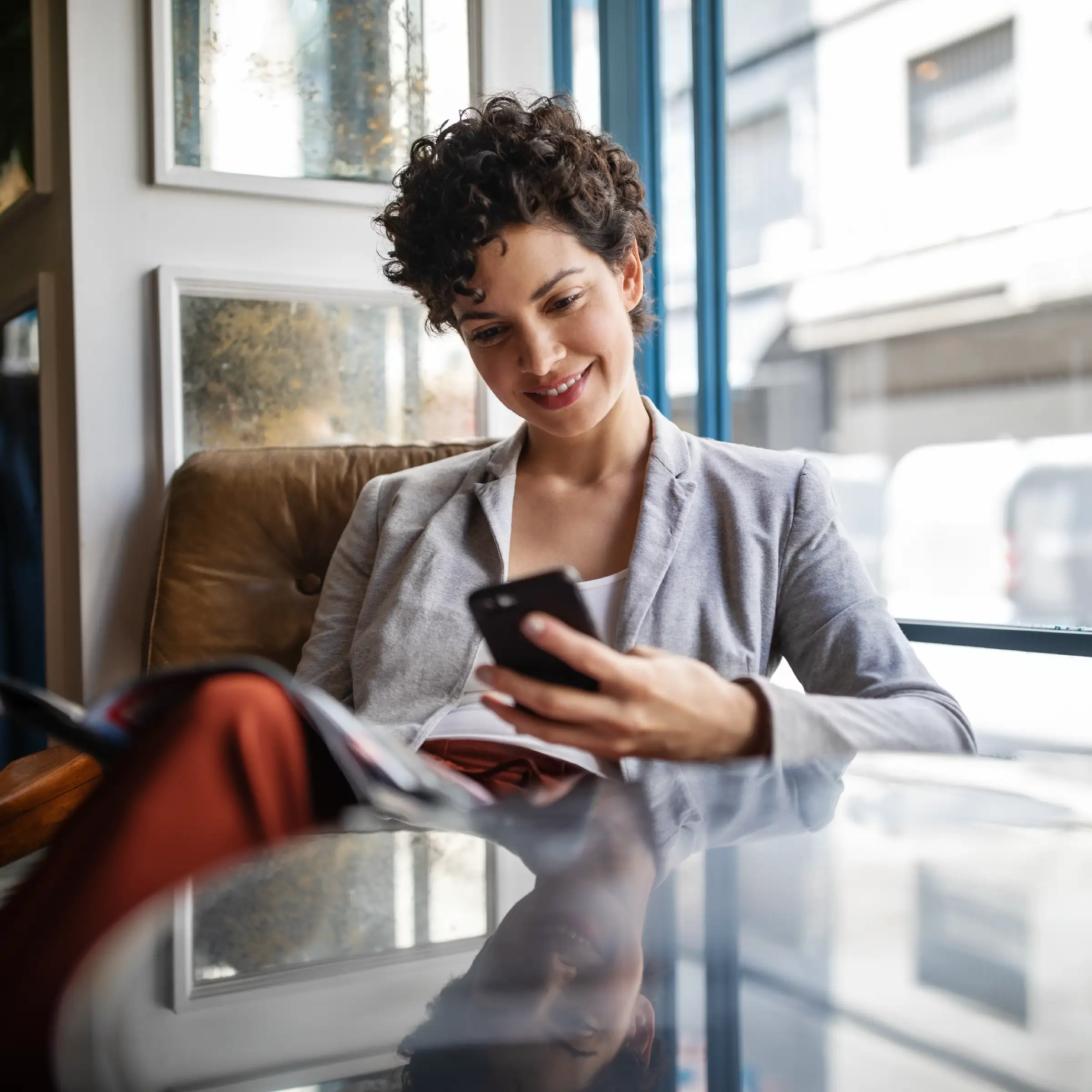 Woman in coffee shop looking at her phone