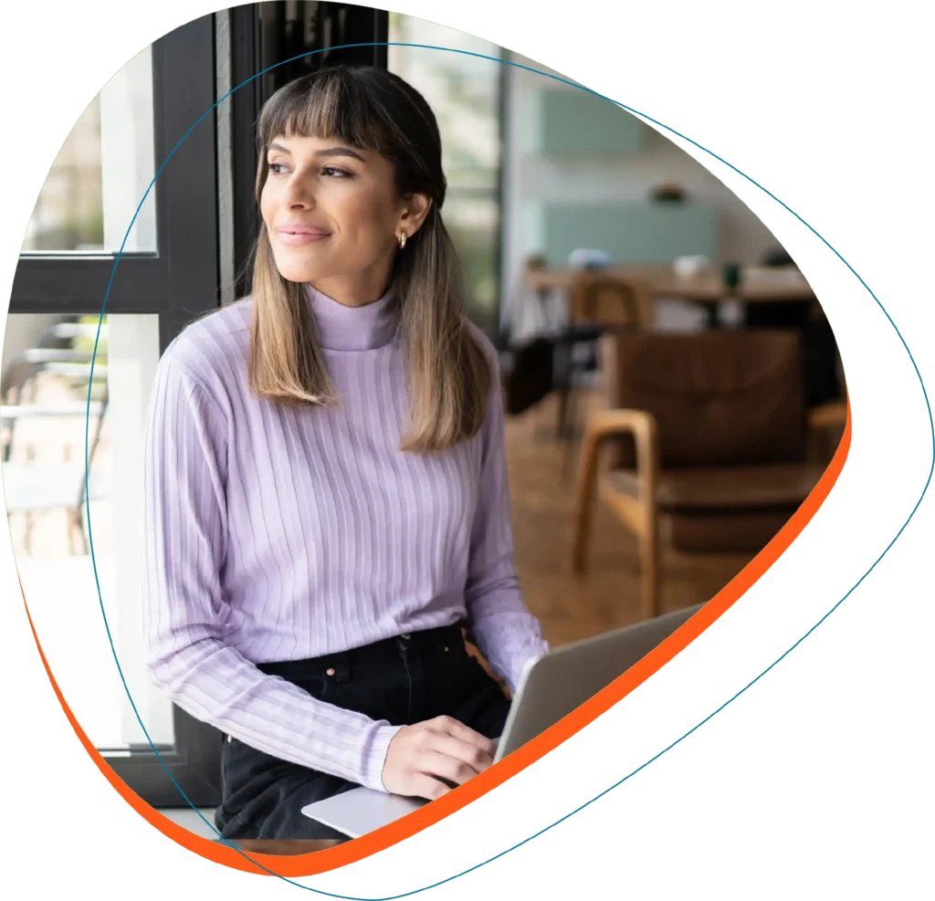 Woman in office with laptop looking into the distance